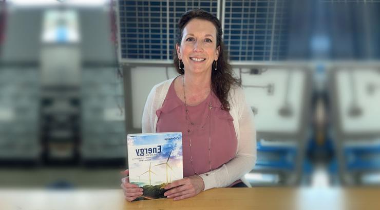 Dr. Jennifer Clemons holding energy textbook.
